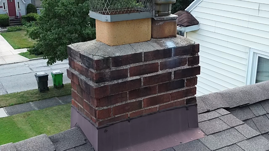Why Is My Chimney Leaking When It Rains? The 5 Usual Causes in Cleveland Homes 2 Lewis Chimney Chase cover on a residential roof